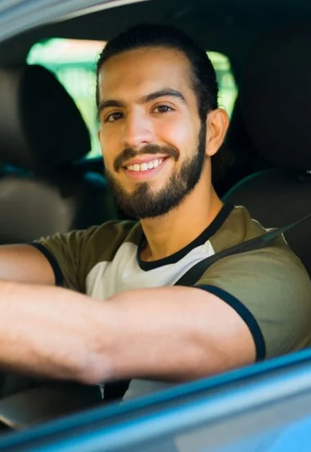 Jonathan, a ride-share driver, smiling at the wheel