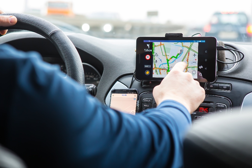A driver reaching over to touch a mounted navigation screen while driving